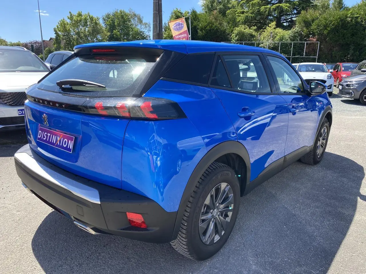 Peugeot 2008 bleu en 3/4 arrière droit, avec feux arrière à griffes et jantes alliage distinctives.