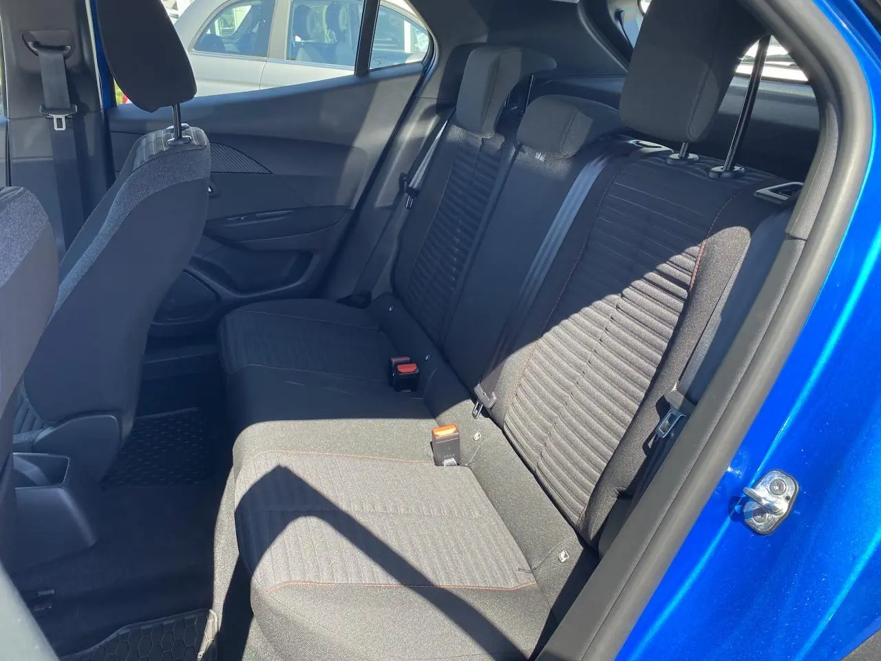 Vue intérieure côté droit des sièges arrière noirs du Peugeot 2008 bleu 2021 avec porte ouverte.