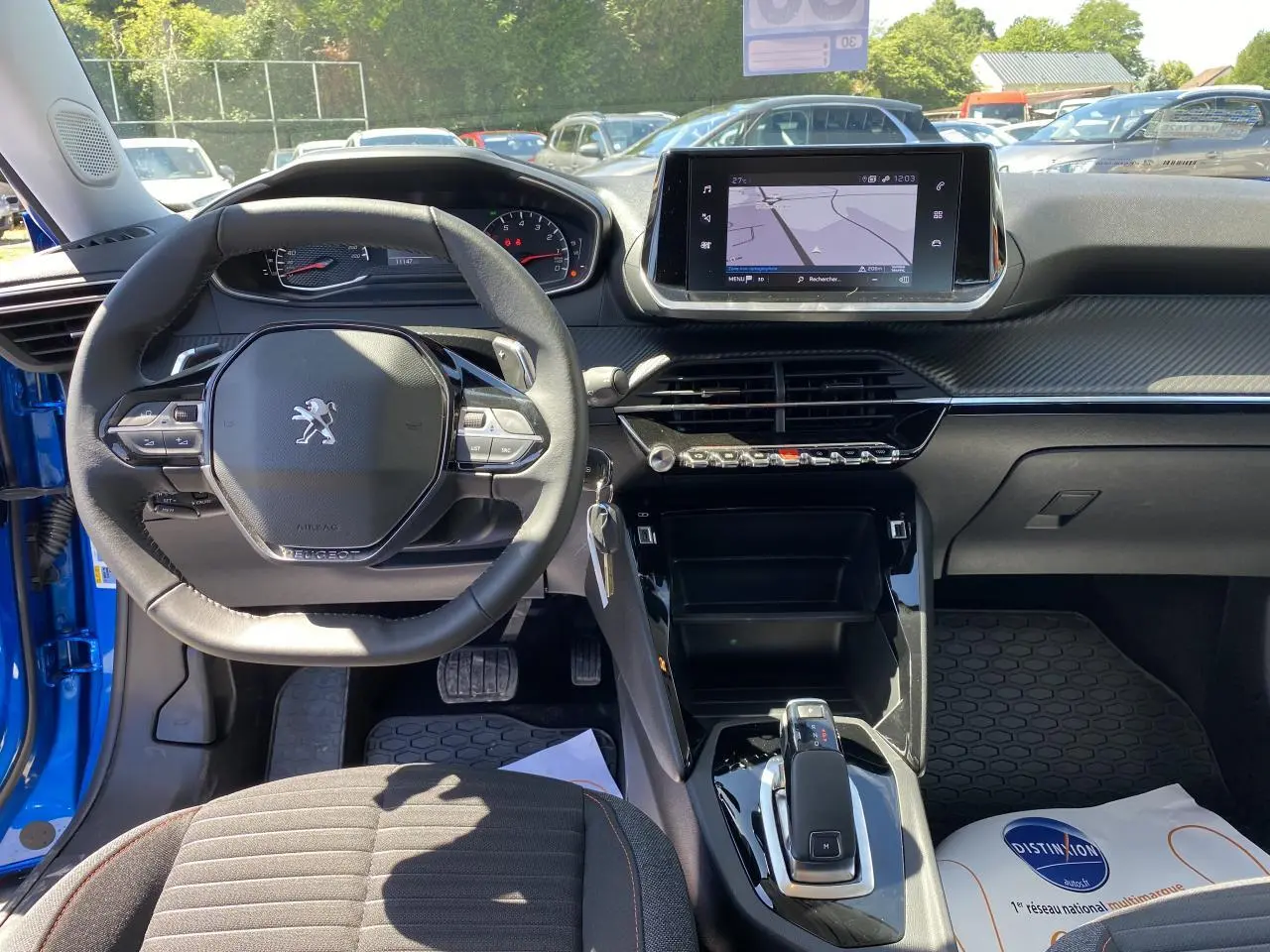 Intérieur de la Peugeot 2008 bleu 2021, vue du poste de conduite avec volant compact et écran tactile central.