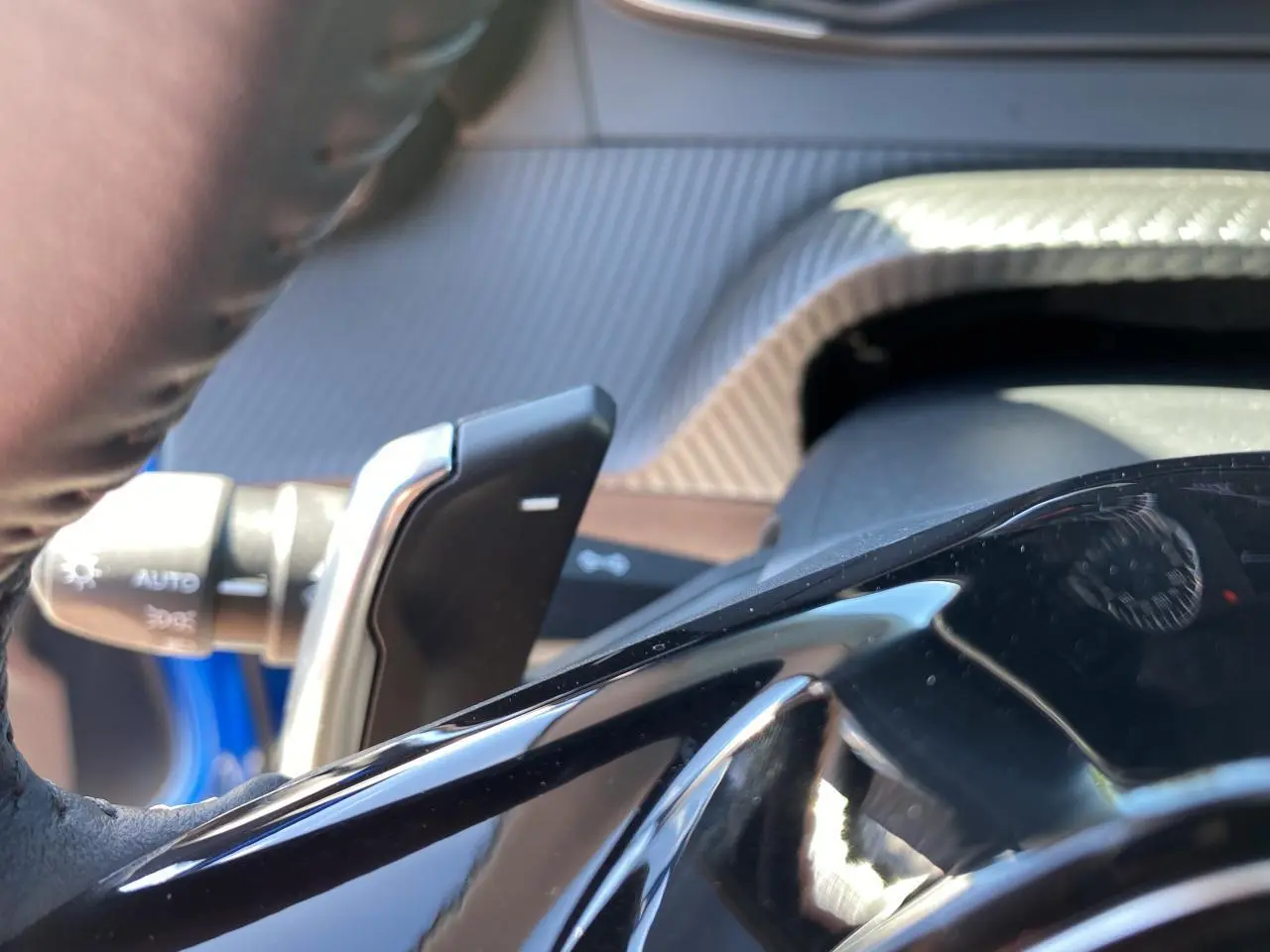 Détail de la palette de changement de vitesse sur le volant d'un Peugeot 2008 bleu 2021, version Active Pack.