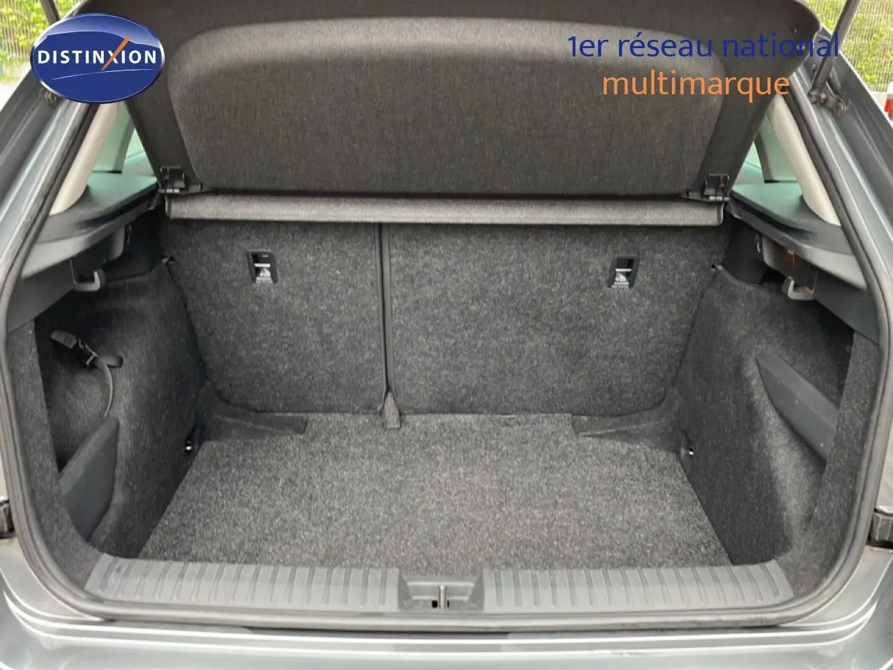 Coffre ouvert vu de l'arrière d'un Skoda Kamiq gris graphite métal, montrant un espace de chargement propre et spacieux.