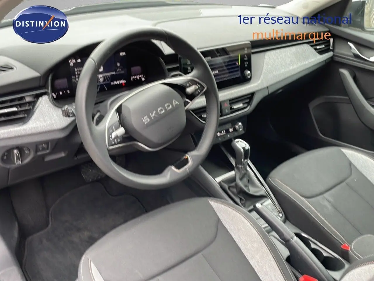 Vue intérieure côté conducteur du Skoda Kamiq 2025 gris graphite, avec volant cuir multifonction et console centrale moderne.