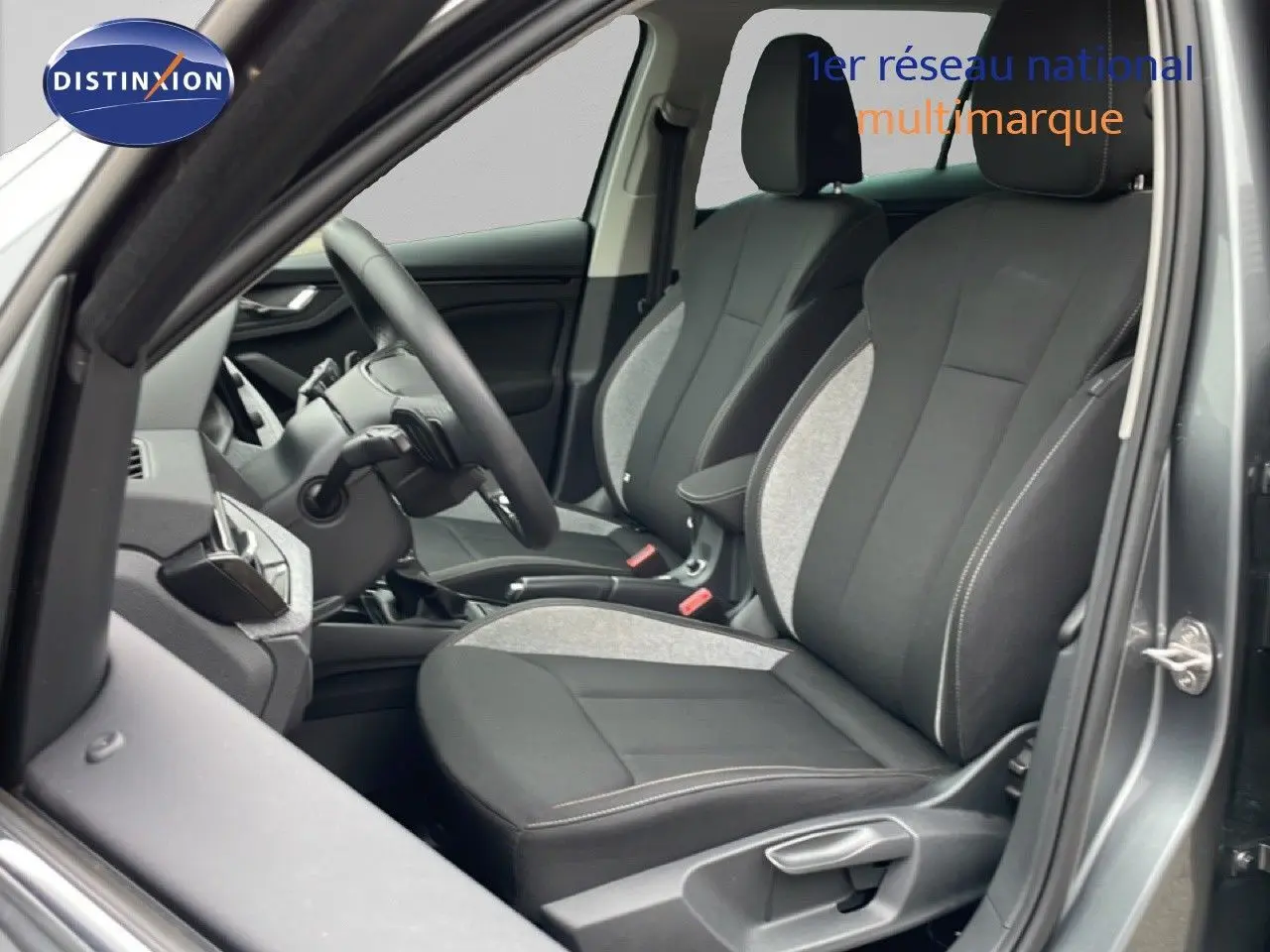 Vue intérieure côté conducteur du Skoda Kamiq 2025 gris graphite, sièges tissu noir et gris avec volant multifonction.