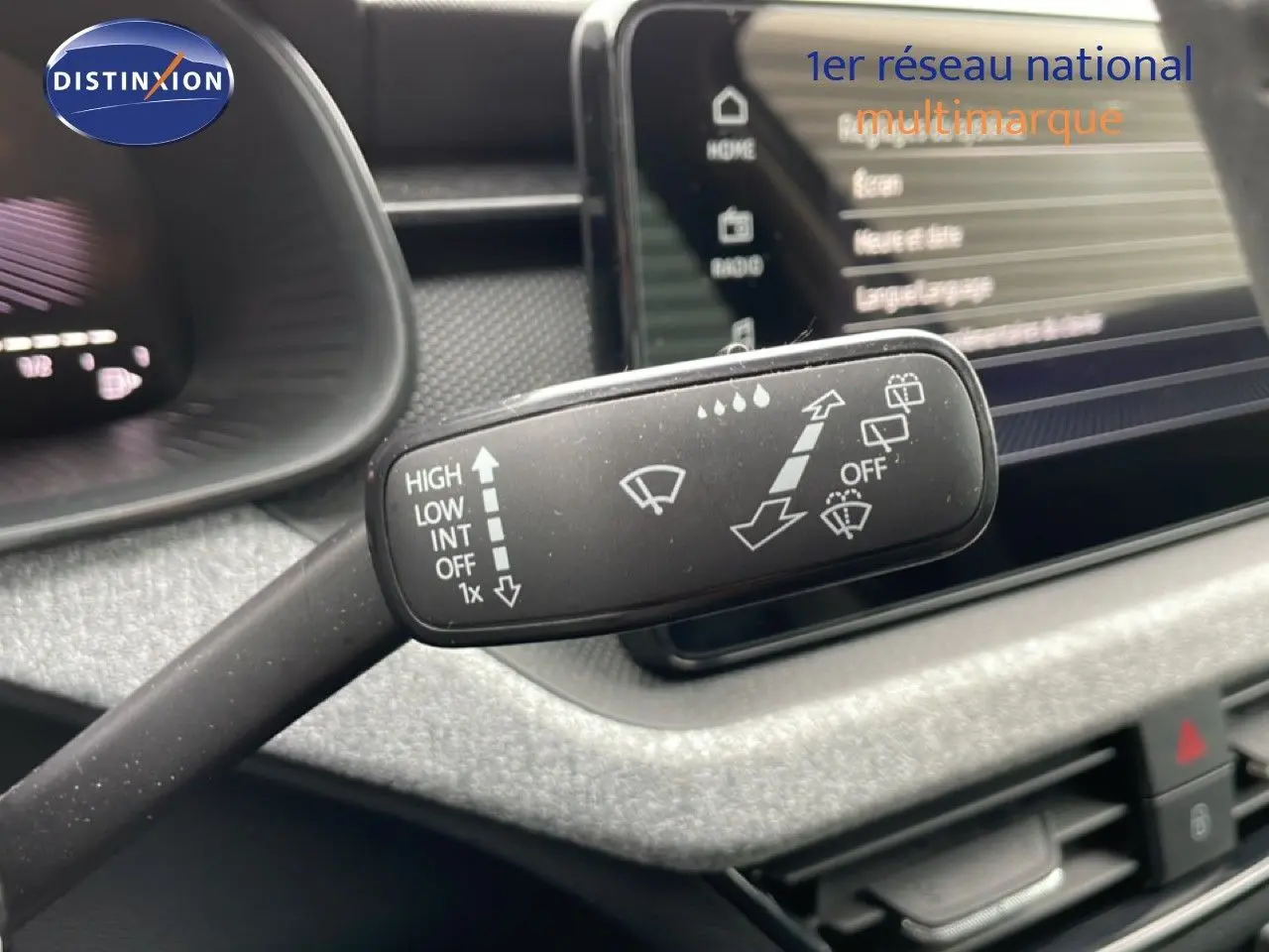 Gros plan sur la manette d’essuie-glace du Skoda Kamiq 2025, intérieur gris graphite avec tableau de bord et écran tactile.