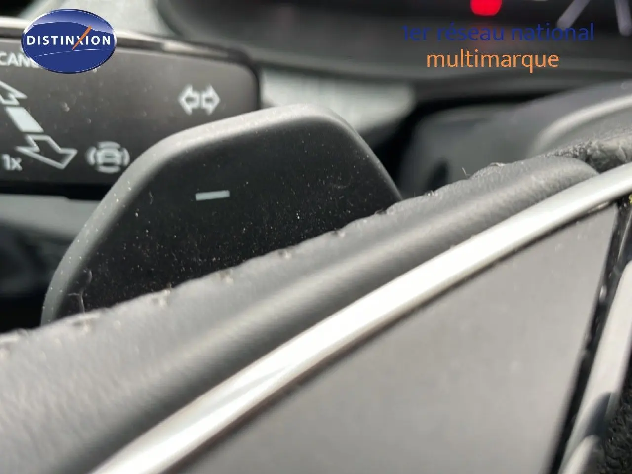 Gros plan sur la palette de changement de vitesse au volant d’un Skoda Kamiq gris graphite, intérieur cuir noir.
