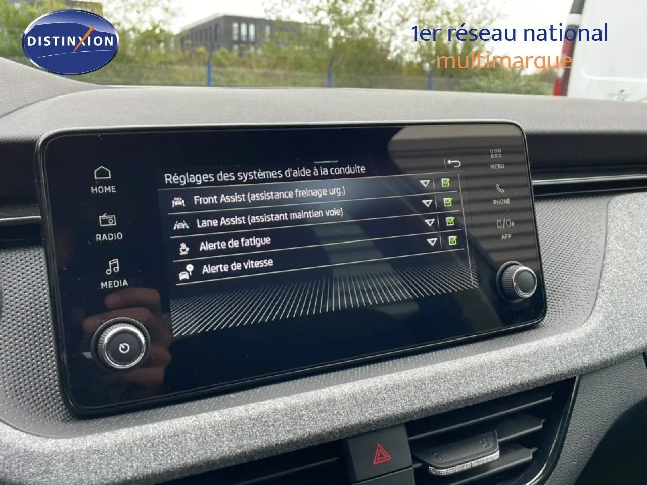 Écran tactile du système d’aide à la conduite dans un Skoda Kamiq 2025, tableau de bord gris clair texturé.