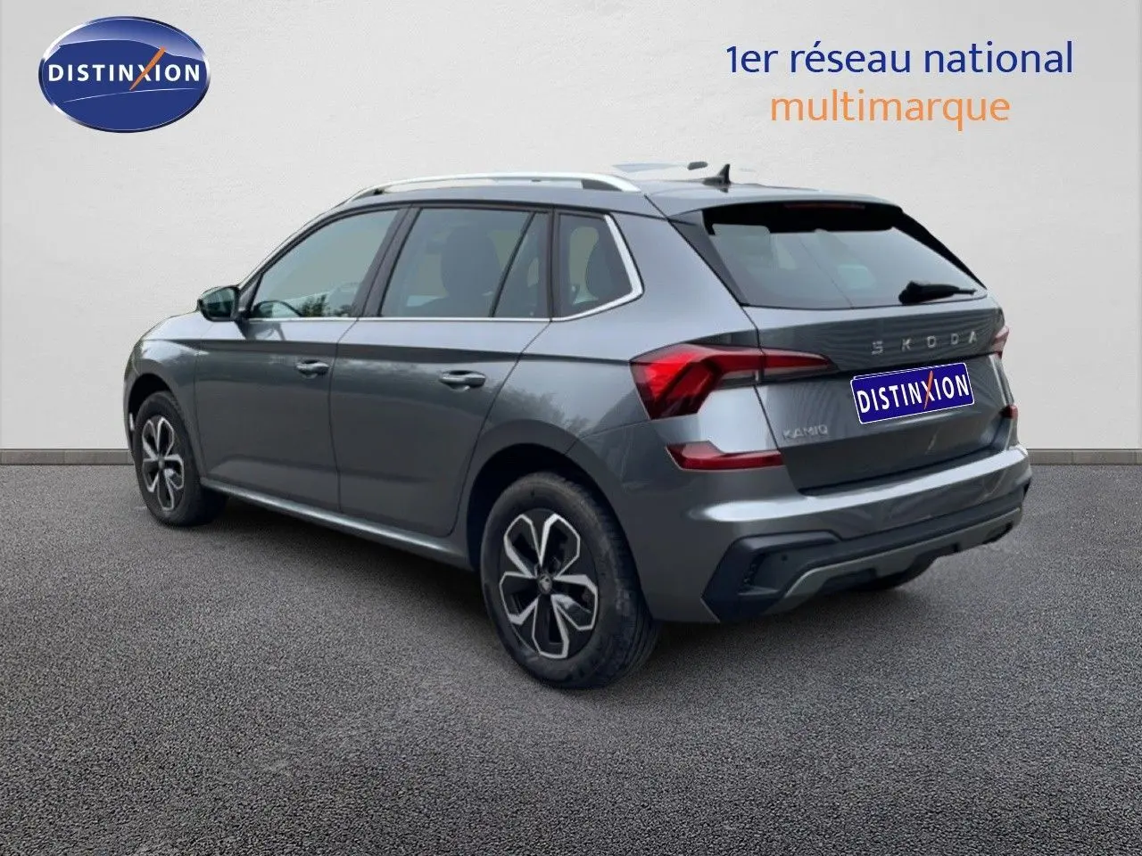 Vue 3/4 arrière droite d'un Skoda Kamiq gris graphite métal avec jantes alliage et toit blanc.