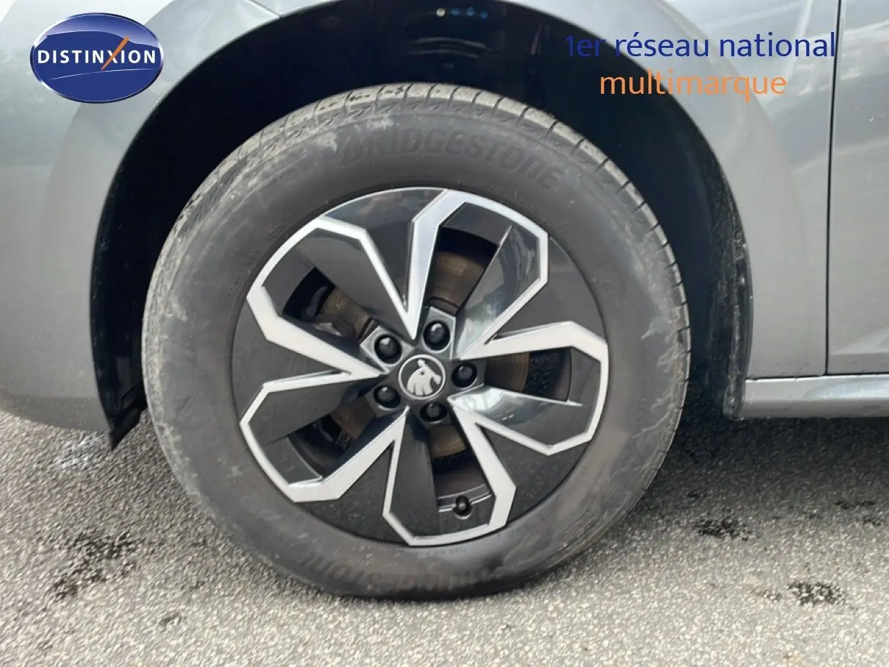 Gros plan sur la roue avant gauche du Skoda Kamiq gris graphite métal, mettant en valeur la jante au design moderne.