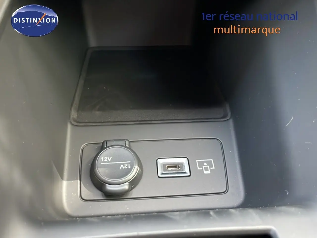 Prise 12V et port USB-C en gros plan dans l'habitacle d'une Peugeot 308 gris Artense hybride 2026.