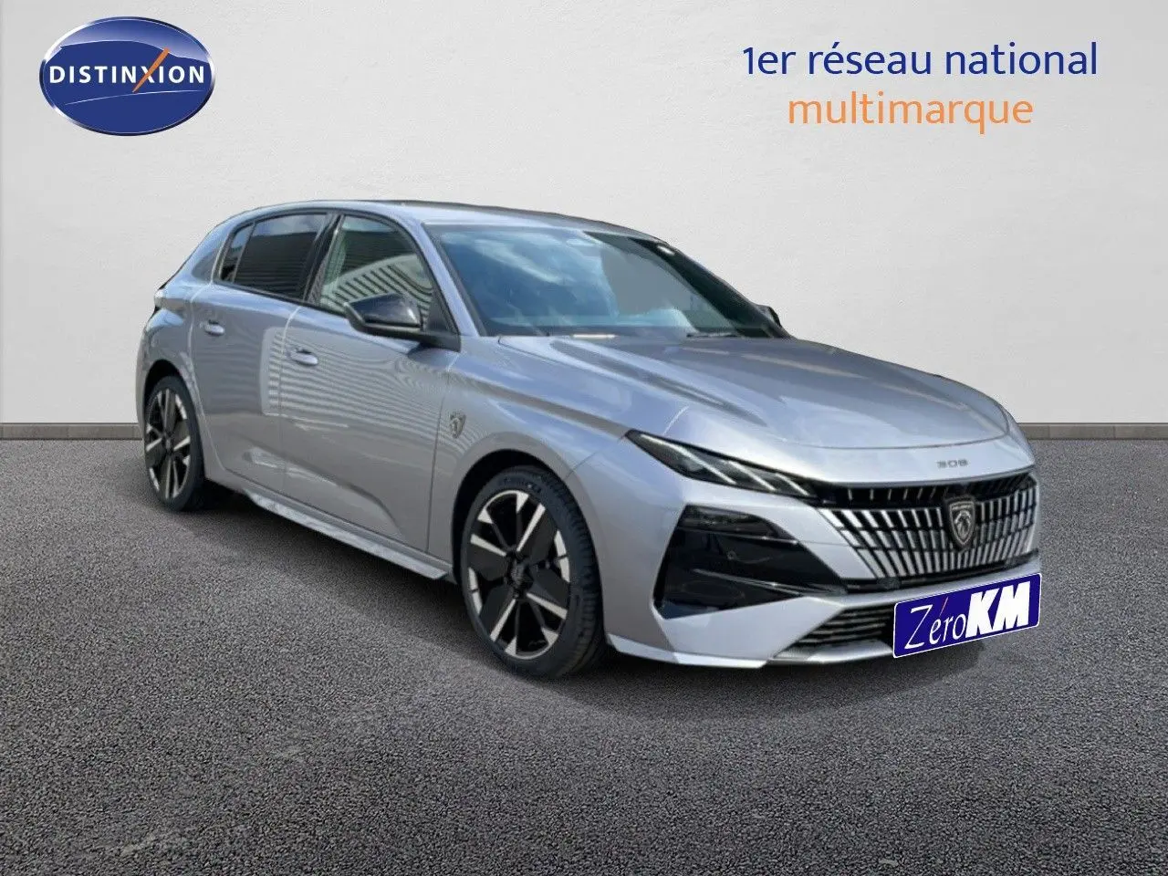 Peugeot 308 gris Artense métal vue 3/4 avant droit, avec calandre distinctive et jantes noires bicolores.