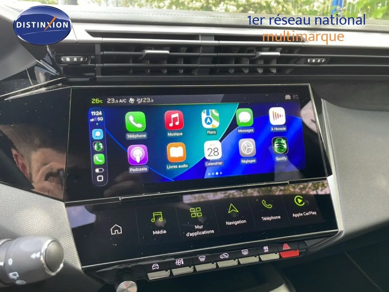 Vue rapprochée de l’écran tactile central du tableau de bord de la Peugeot 308 gris Artense, affichant les applications multimédia.