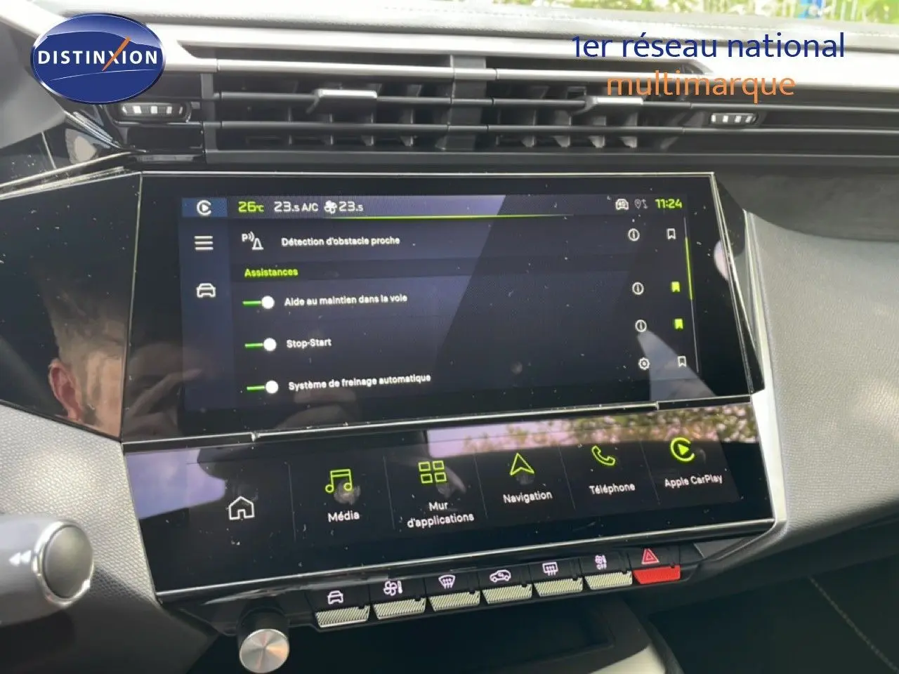 Vue rapprochée de l’écran tactile central et de la console d’une Peugeot 308 gris Artense, affichant les aides à la conduite.