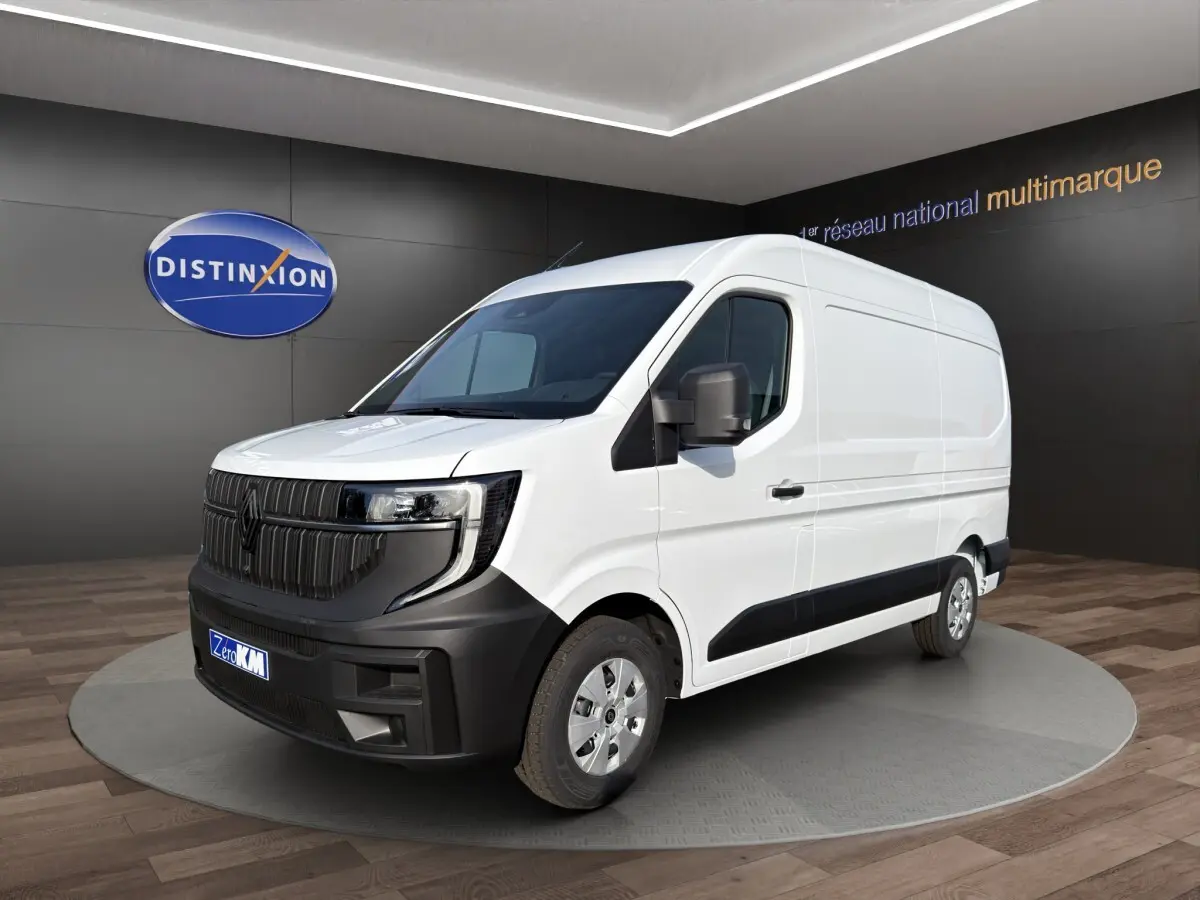 Renault Master blanc en 3/4 avant droit, avec calandre noire et pare-chocs contrastant visible en intérieur showroom.