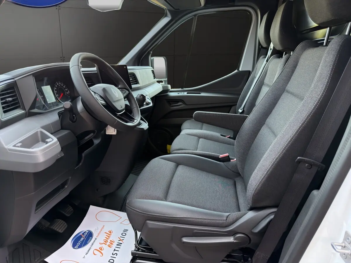 Vue intérieure côté conducteur du Renault Master 2026, montrant les sièges gris et le tableau de bord moderne.