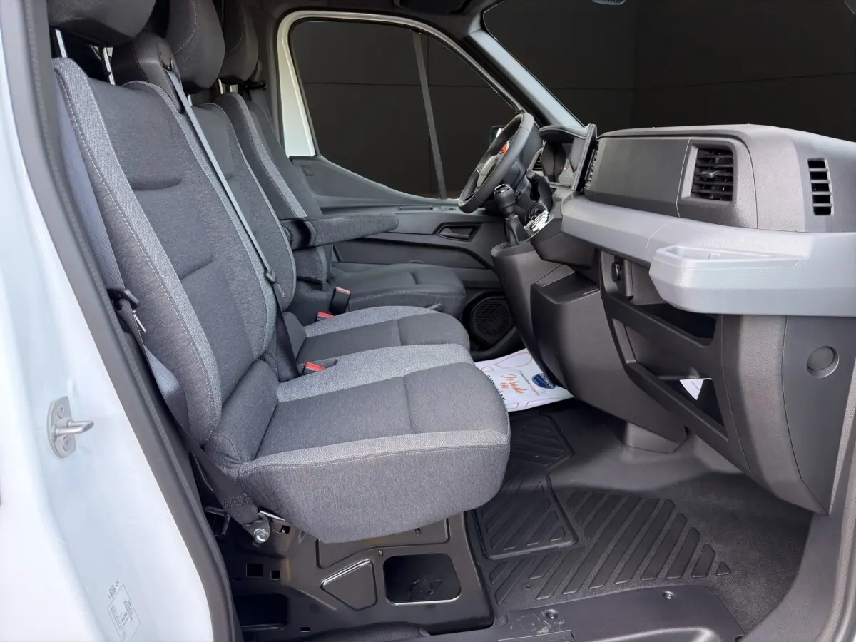 Vue intérieure côté conducteur du Renault Master blanc, montrant les sièges gris et le tableau de bord moderne.