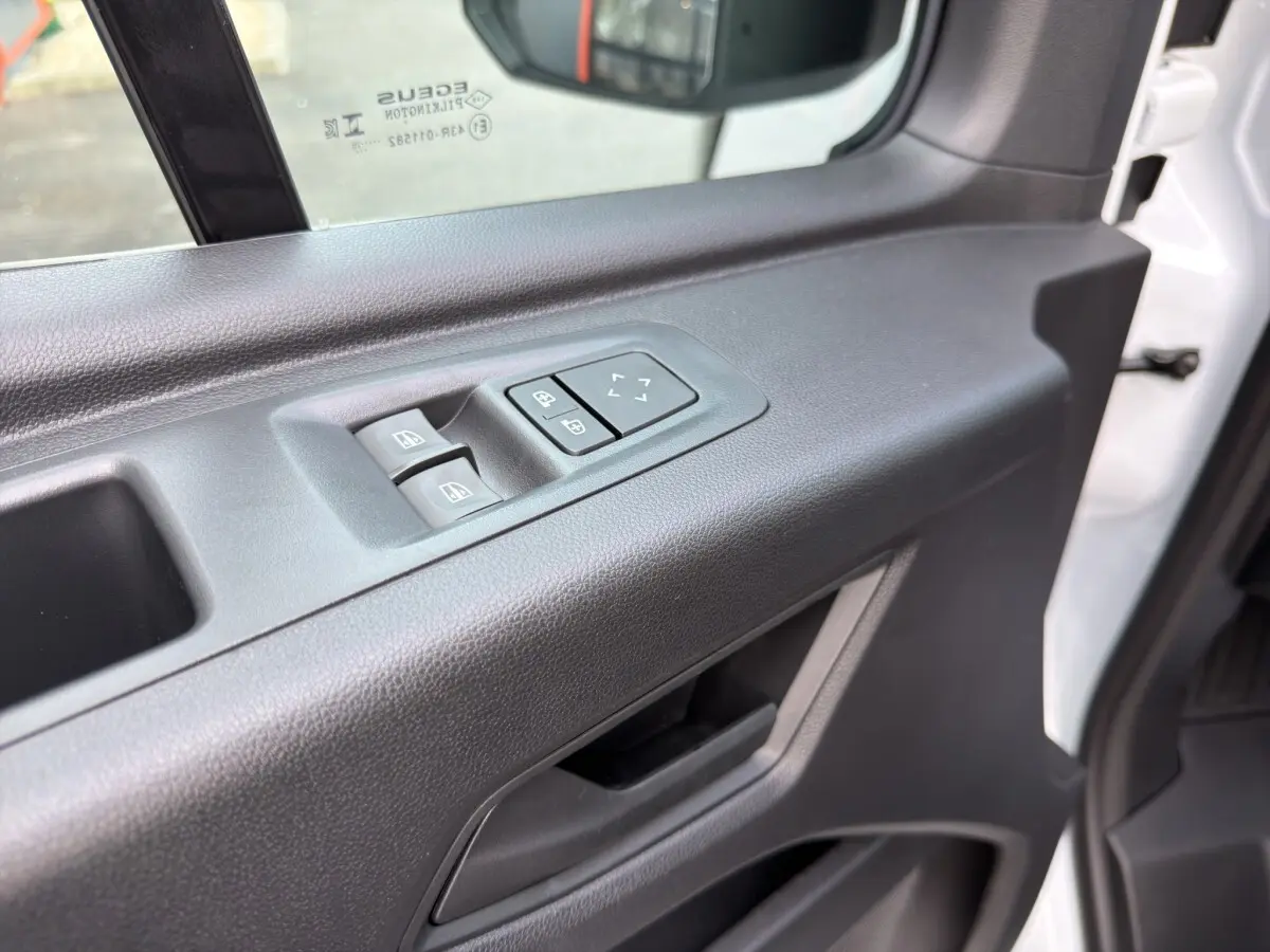Détail de la porte côté conducteur du Renault Master blanc 2026, avec commandes électriques des vitres et réglage des rétroviseurs.