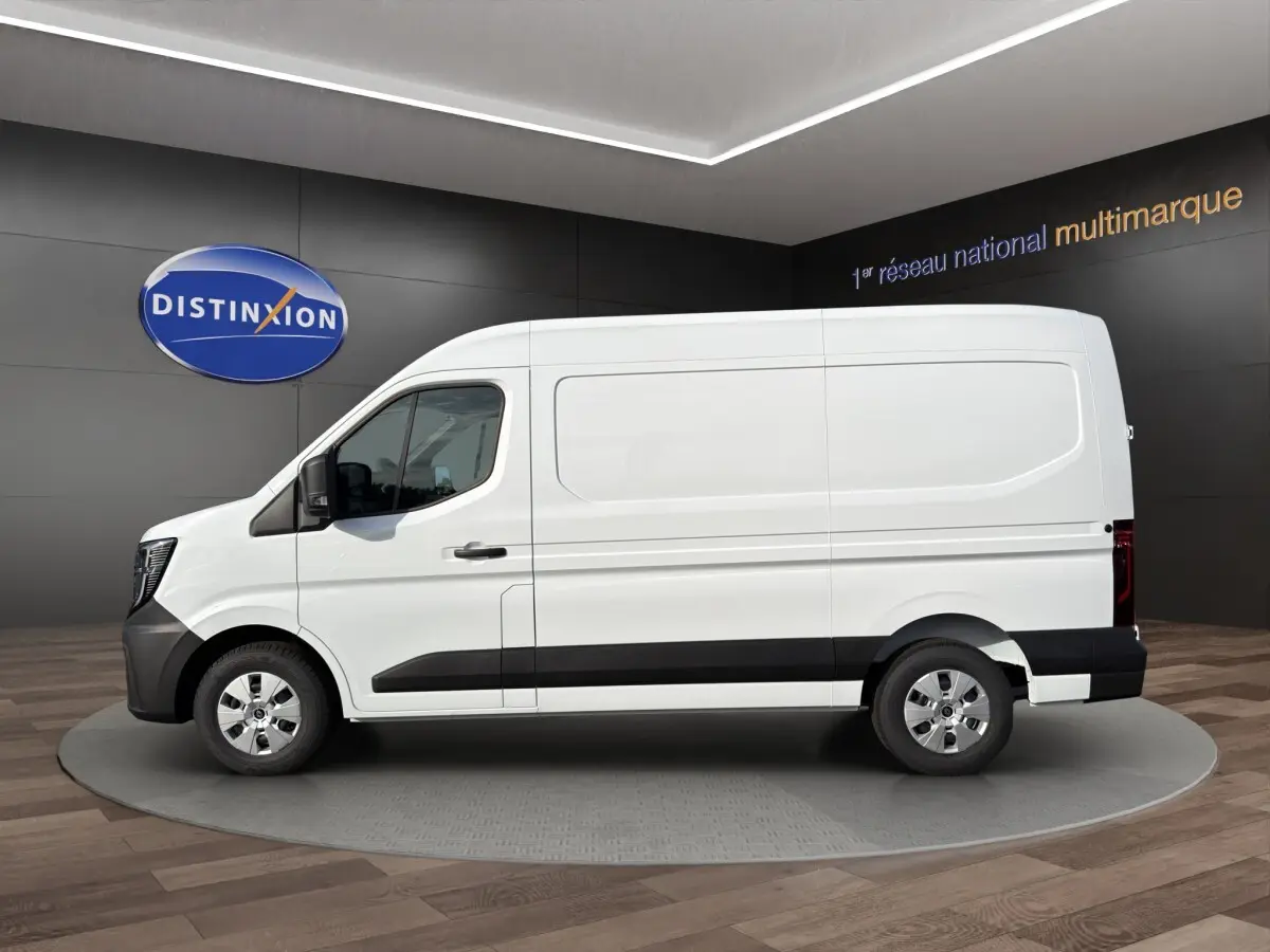 Vue de profil côté gauche d’un Renault Master blanc avec bande noire basse et jantes argentées, en showroom.