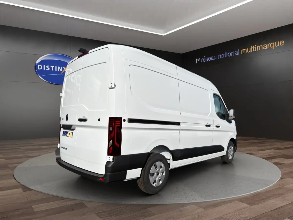 Renault Master blanc en 3/4 arrière droit, fourgon utilitaire avec feux arrière LED et protections latérales noires.