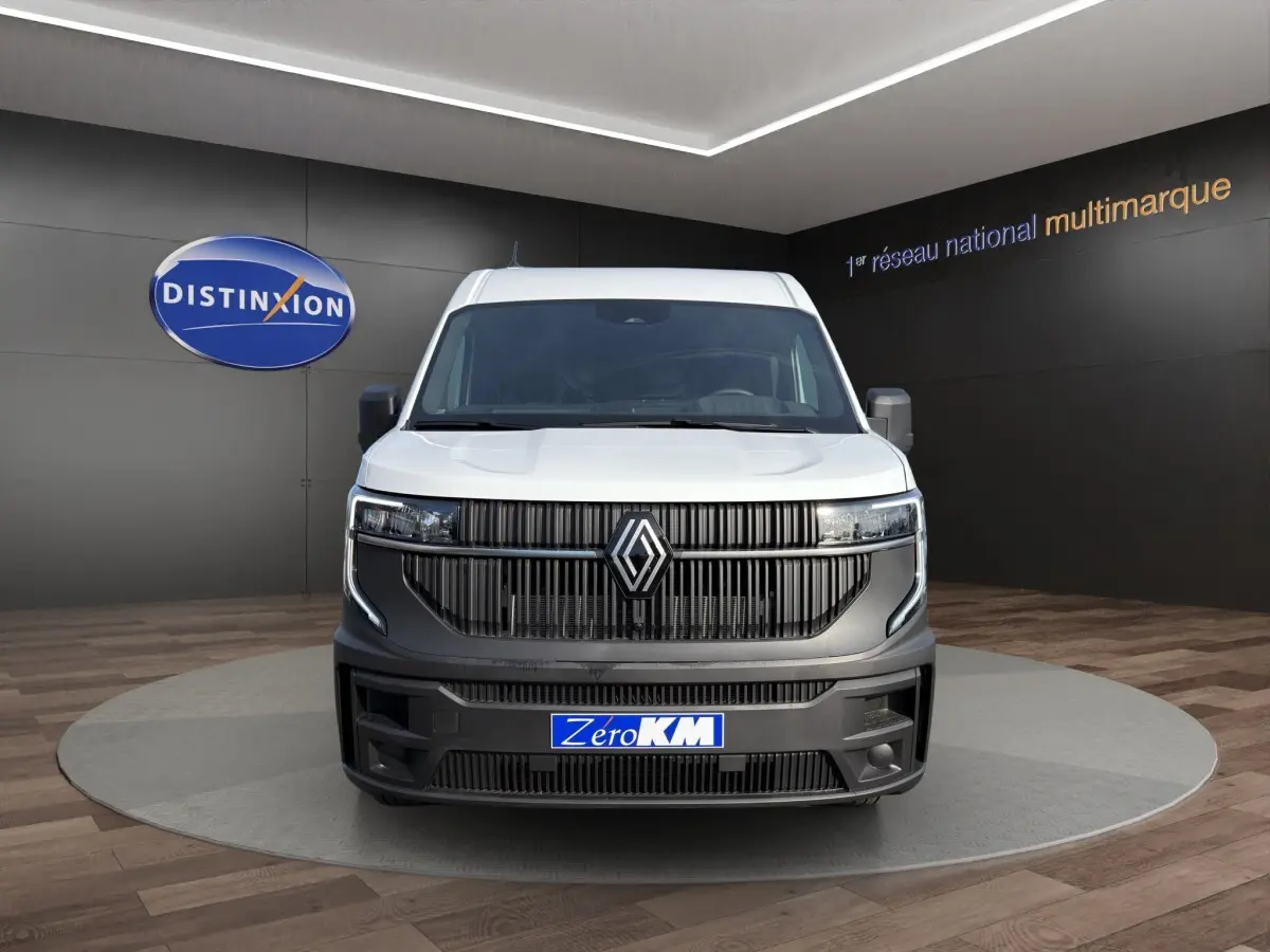 Vue avant du Renault Master blanc avec calandre noire et logo Renault proéminent en showroom.