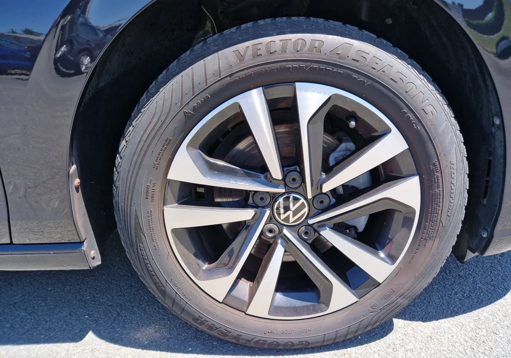 Gros plan sur la roue avant gauche noire métallisée d'une Volkswagen Golf VIII avec jante alliage bicolore.