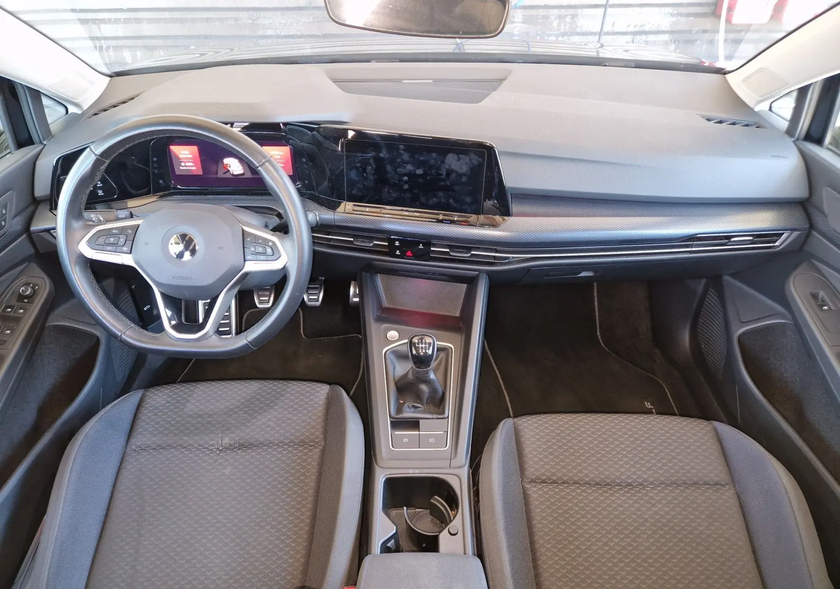 Intérieur de la Volkswagen Golf VIII 2.0 TDI 115CH United 2021, vue du tableau de bord et console centrale avec boîte manuelle.