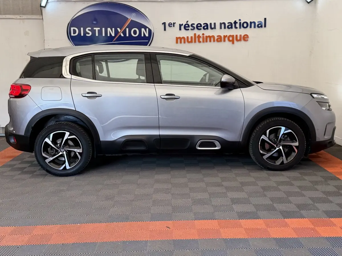 Profil côté droit d'un Citroën C5 Aircross gris clair 2020, avec jantes alliage et protections noires sur les bas de caisse.