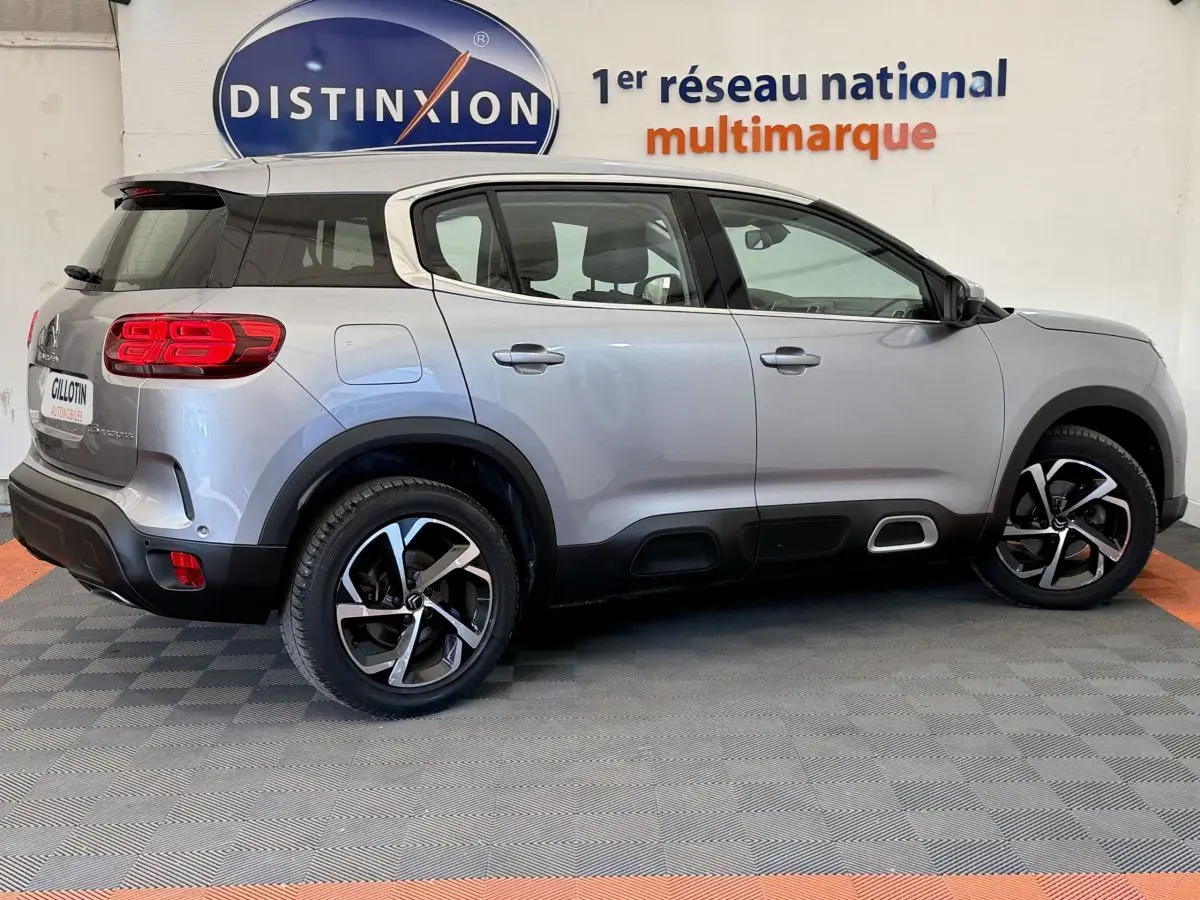 Profil droit d'un Citroën C5 Aircross gris clair 2020 avec jantes noires et détails noirs sur les bas de caisse.
