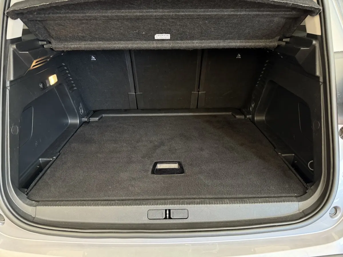 Coffre ouvert vu de l'arrière d'une Citroën C5 Aircross gris clair, espace de chargement propre et bien fini.