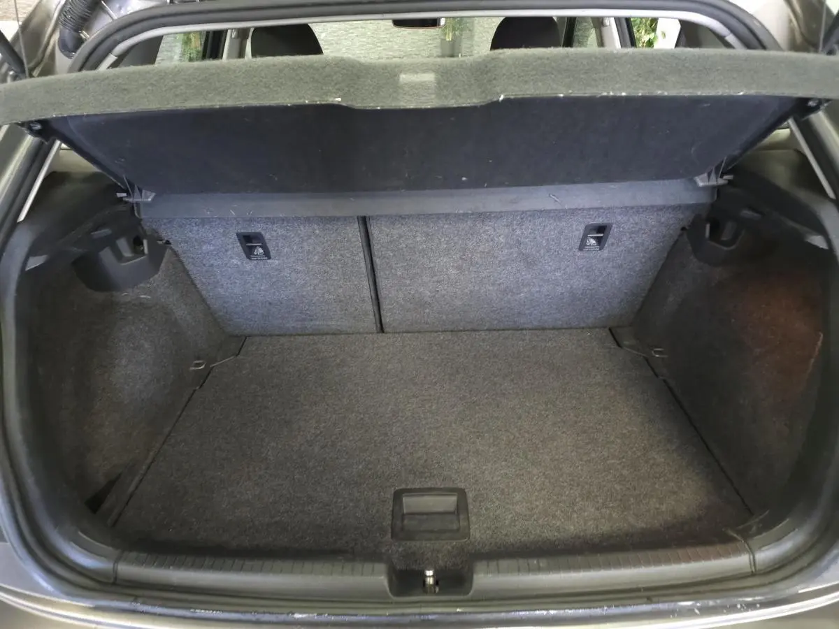 Coffre ouvert de la Volkswagen Polo gris, montrant l'espace de chargement et la tablette cache-bagages relevée.