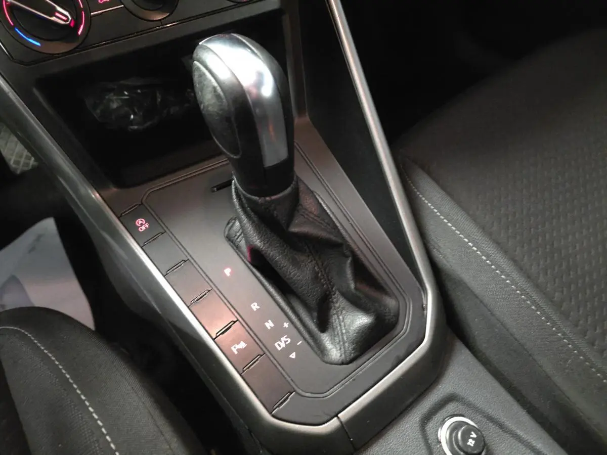 Le levier de vitesses automatique en cuir noir de la Volkswagen Polo 1.6 TDI Lounge Business 2020, vue rapprochée de la console centrale.