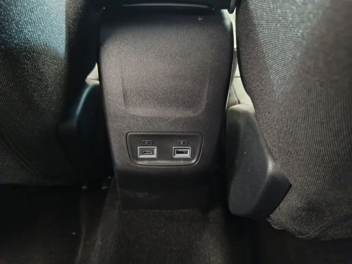 Prise USB avant et arrière visibles entre les sièges avant d'une Peugeot 208 gris foncé, vue rapprochée intérieure.