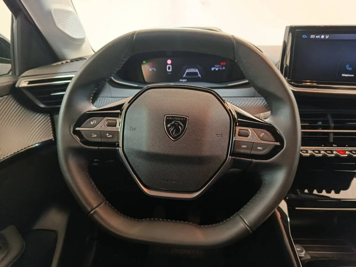 Volant cuir noir de Peugeot 208 PureTech 100 S&S Allure 2025 vu de face avec tableau de bord numérique et écran tactile.