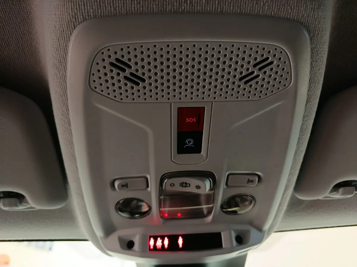 Vue rapprochée du plafonnier intérieur gris clair de la Peugeot 208 PureTech 100 S&S Allure avec bouton SOS éclairé rouge.