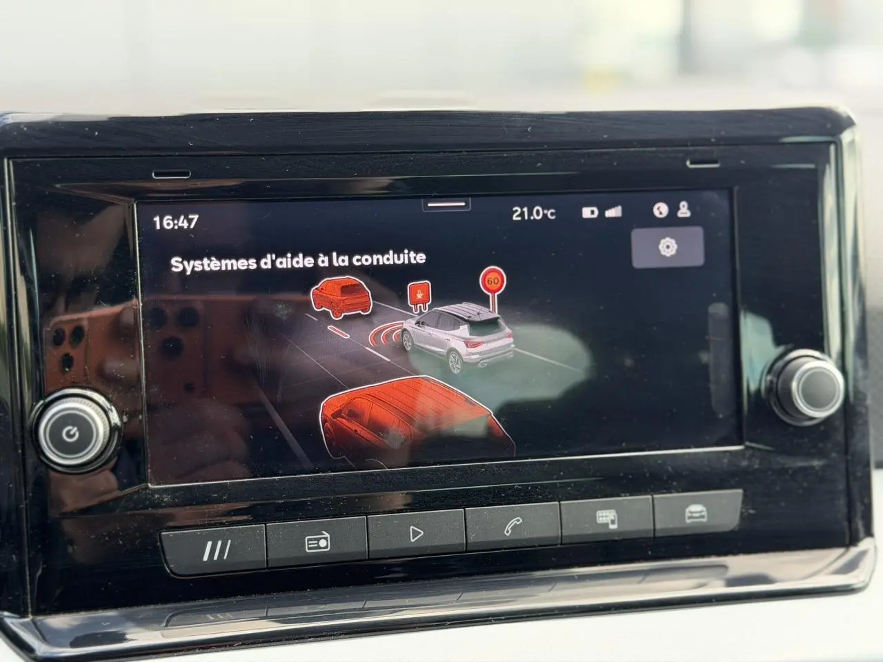 Écran tactile du système d'info-divertissement montrant les aides à la conduite dans un SEAT Arona Rouge Désir.