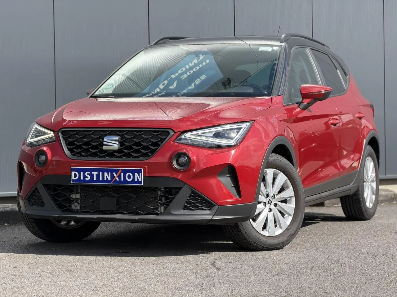 SEAT Arona TSI 115 Style rouge Désir en 3/4 avant droit avec calandre noire et jantes alliage 16 pouces.
