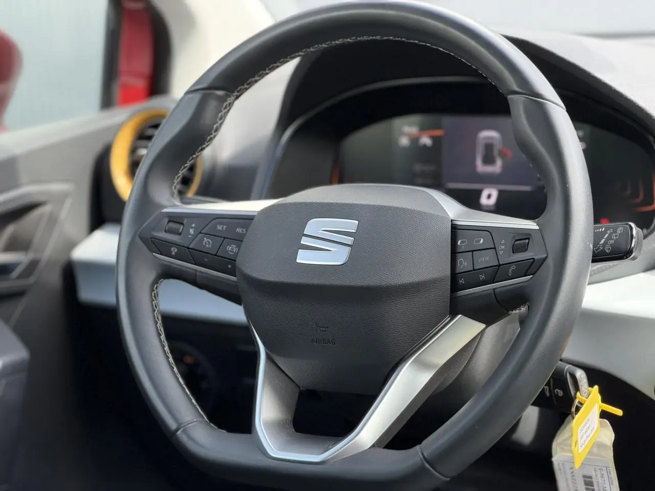 Vue rapprochée du volant multifonctions noir de la SEAT Arona 2025 avec tableau de bord digital en arrière-plan.