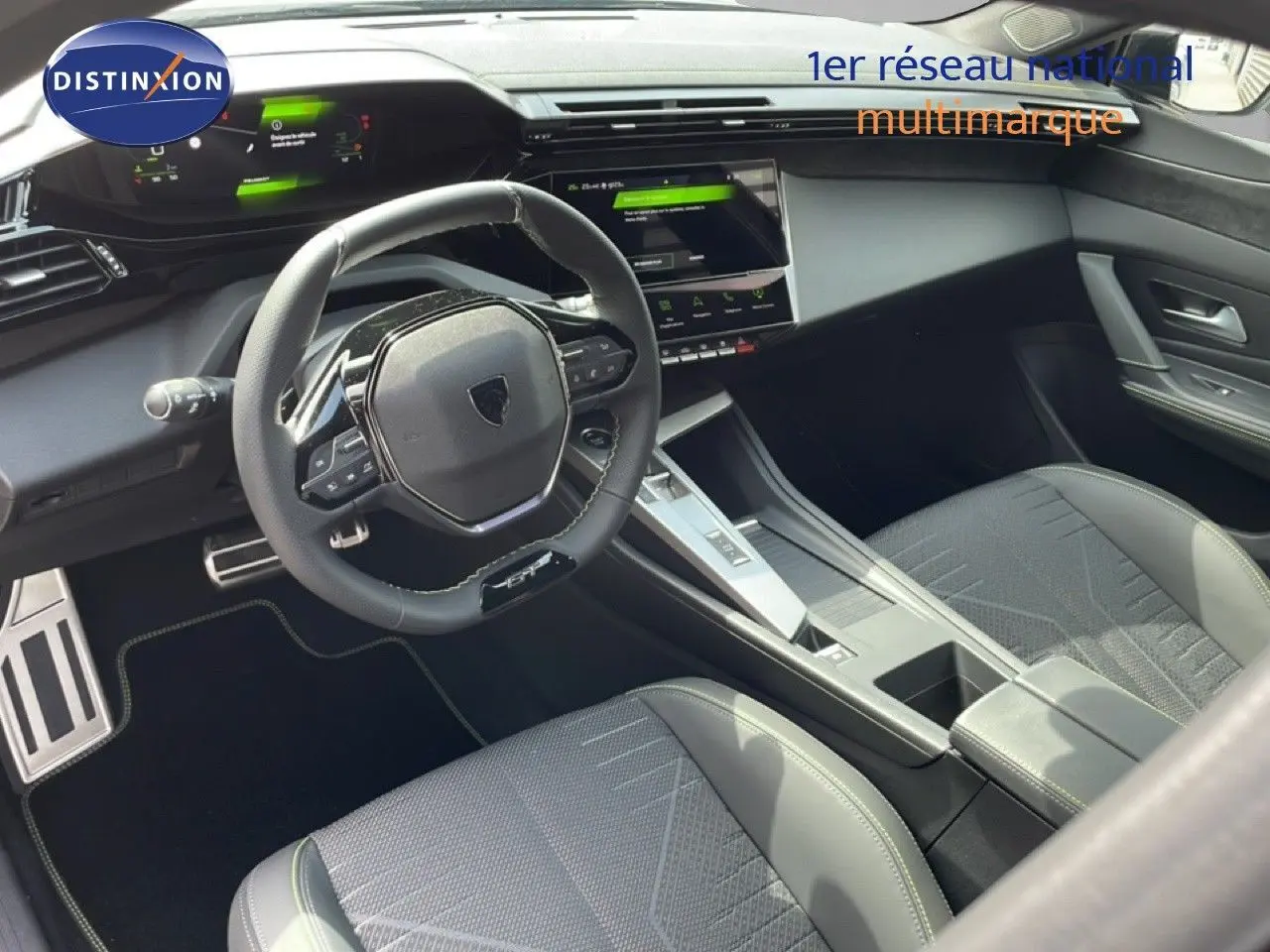 Intérieur noir de la Peugeot 308 1.2 Hybrid 145ch GT, vue côté conducteur sur le volant et la console centrale moderne.