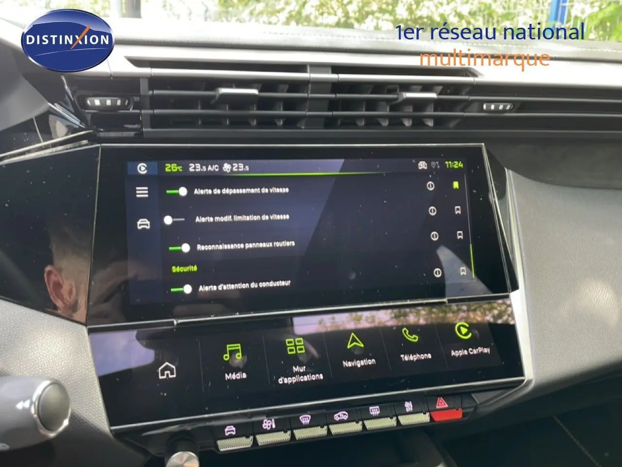 Vue rapprochée de l’écran tactile central du tableau de bord de la Peugeot 308 gris Artense, affichant les options de sécurité et multimédia.
