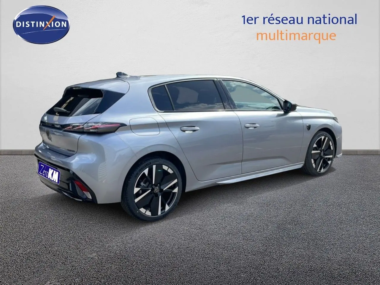 Peugeot 308 1.2 Hybrid gris Artense métal vue 3/4 arrière droit avec jantes noires et détails modernes.