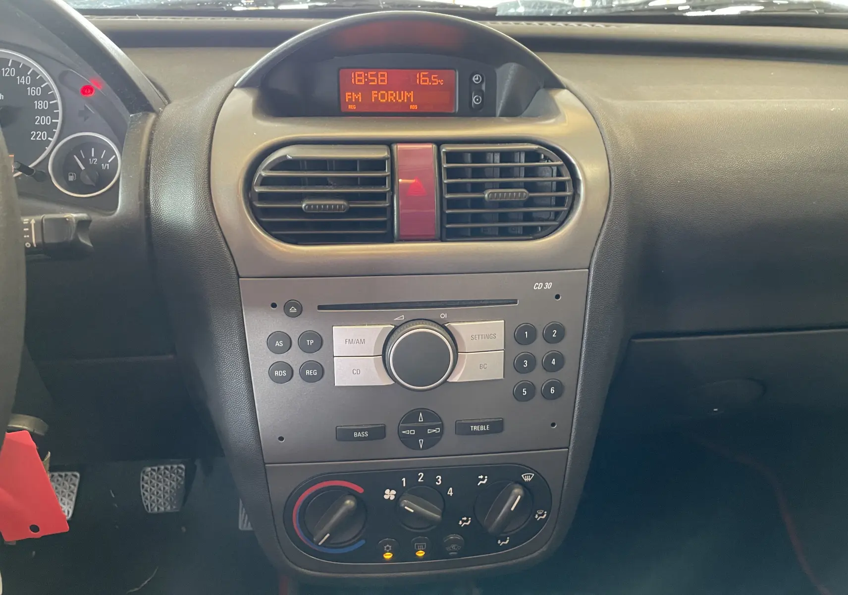 Vue rapprochée du tableau de bord central de l'Opel Tigra Twintop 2006 avec commandes radio et climatisation.