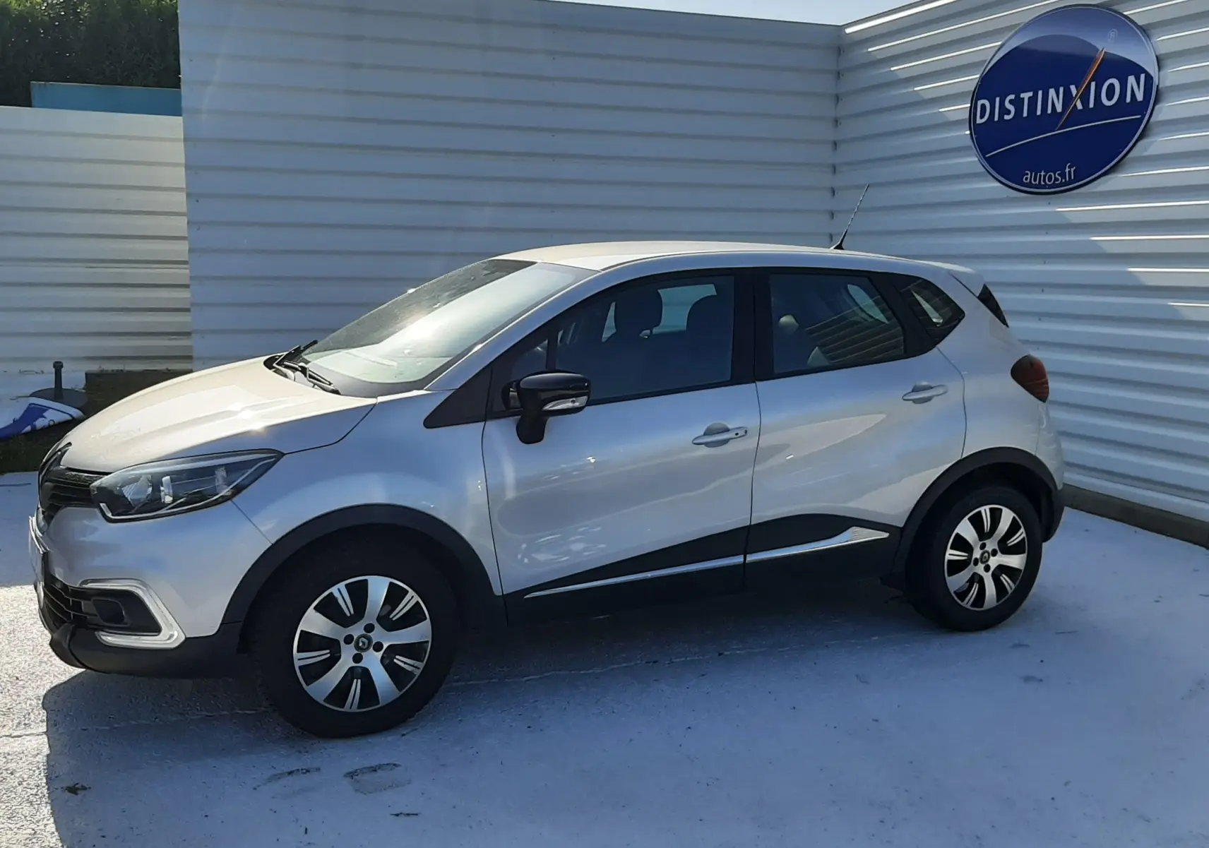 Renault Captur gris platine métal vu de profil côté gauche, avec jantes alliage et rétroviseurs noirs.