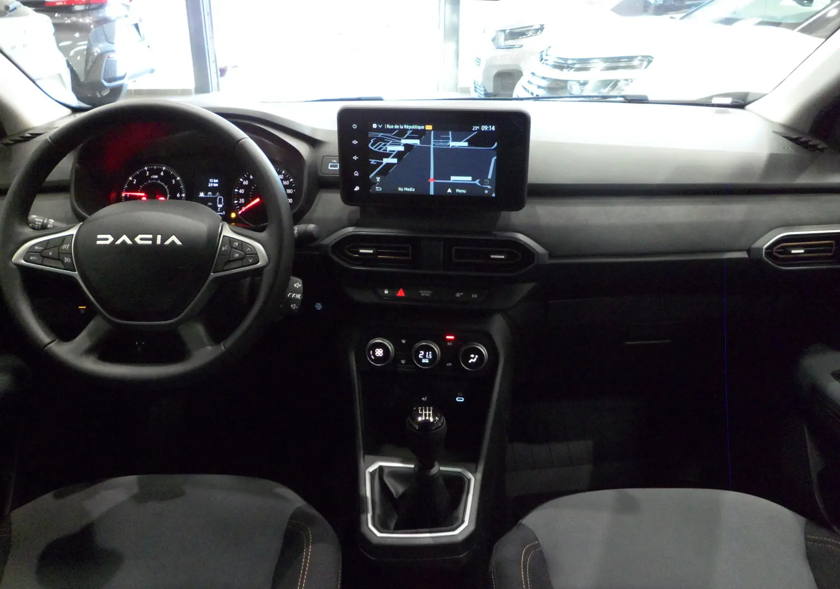 Intérieur du Dacia Jogger TCe 110 Gris Urbain 2025, vue frontale du tableau de bord avec écran tactile et boîte manuelle.