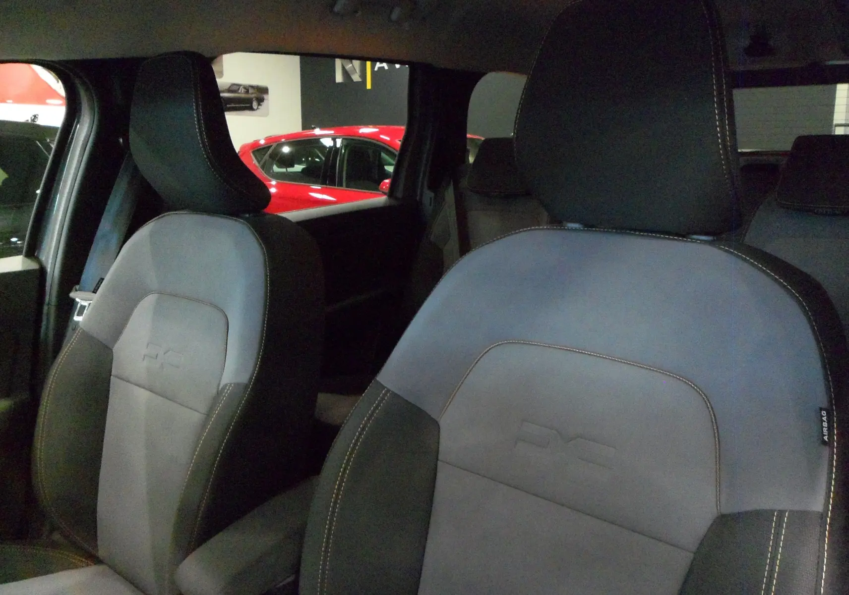 Gros plan sur les sièges avant en tissu gris et noir du Dacia Jogger TCe 110 CH EXTREME 7PL 2025, ambiance intérieure sombre.