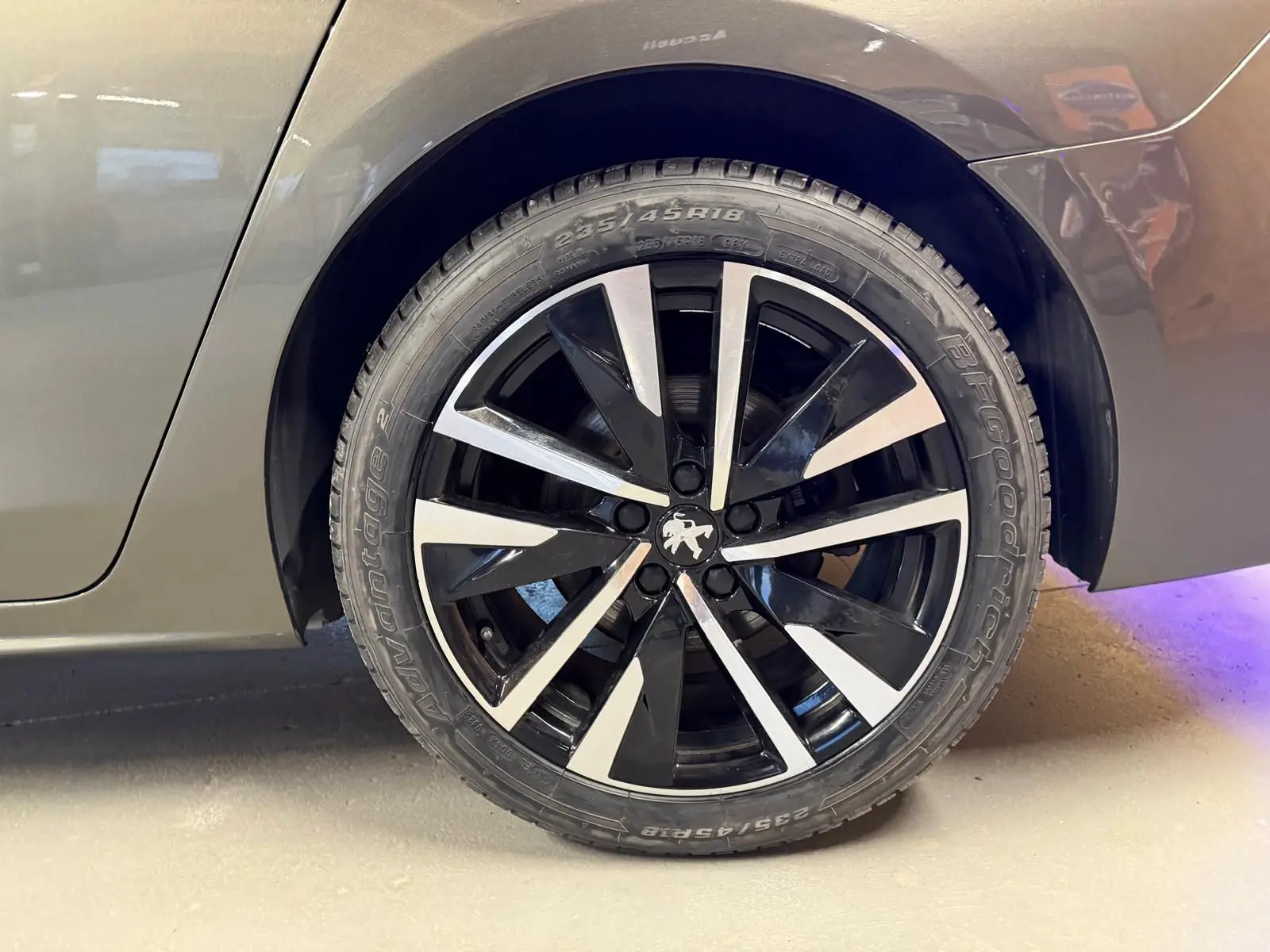 Gros plan sur la jante alu noire et argentée côté arrière droit d'une Peugeot 508 gris métallisé.