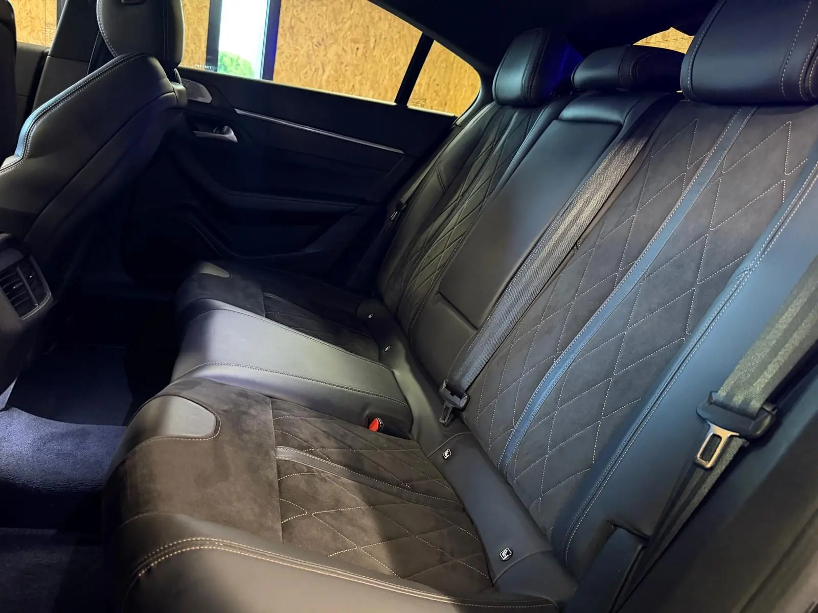 Vue intérieure côté droit des sièges arrière en cuir noir et Alcantara gris de la Peugeot 508 II GT 2019.