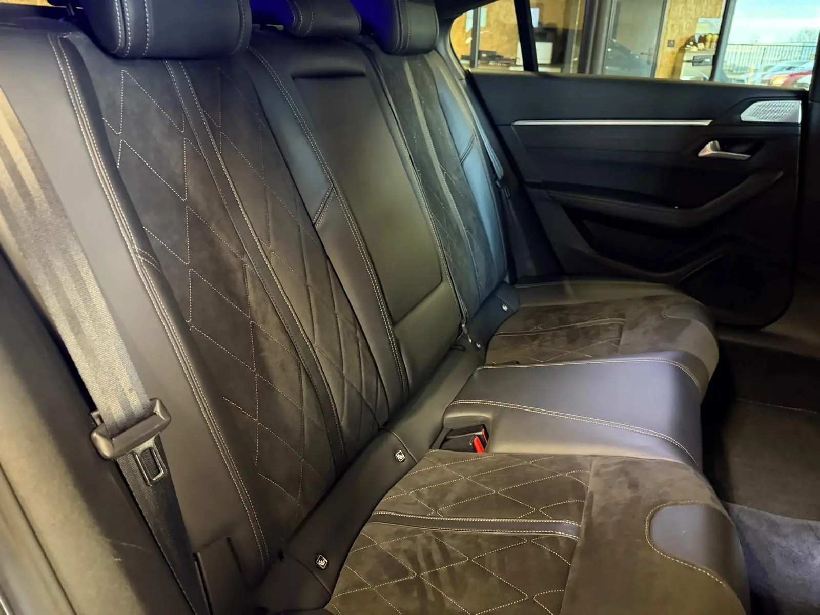 Vue intérieure côté droit sur la banquette arrière cuir noir et Alcantara gris de la Peugeot 508 II GT 2019.