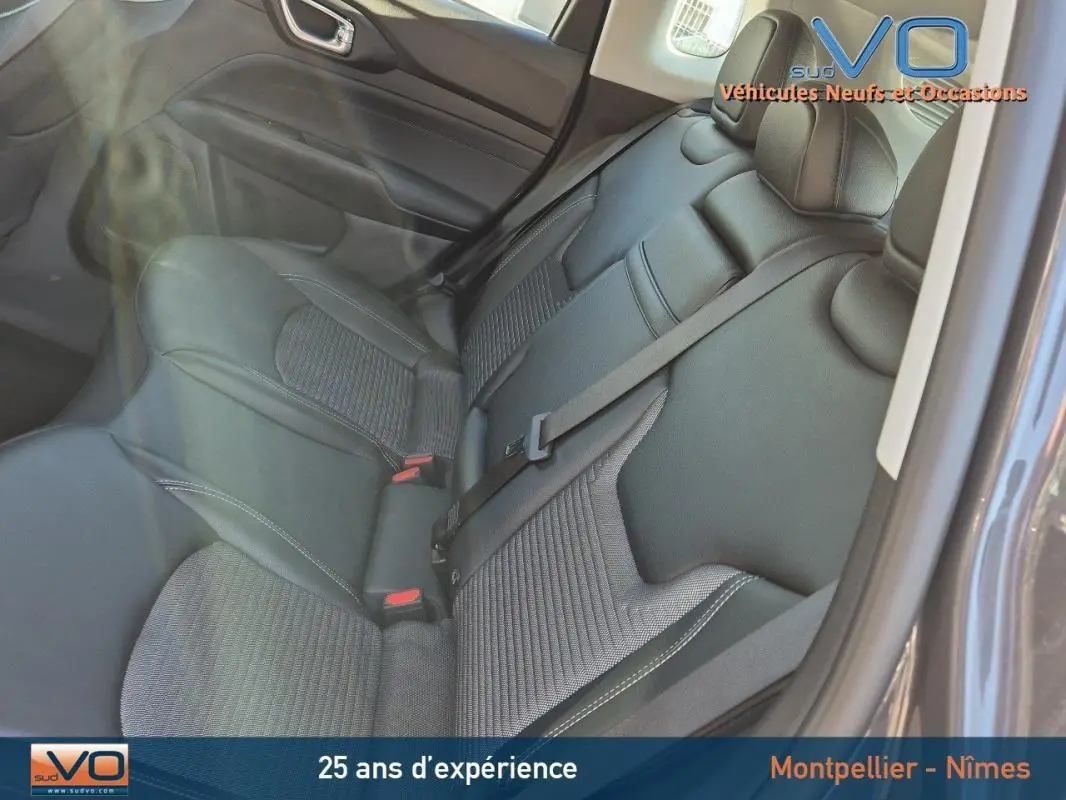 Vue intérieure des sièges arrière en tissu gris du Jeep Compass 2024, avec ceinture de sécurité centrale visible.