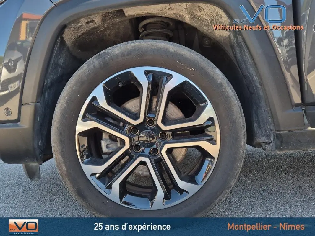 Gros plan sur la jante alliage 18 pouces noire et argentée du Jeep Compass gris 2024, côté gauche avant.