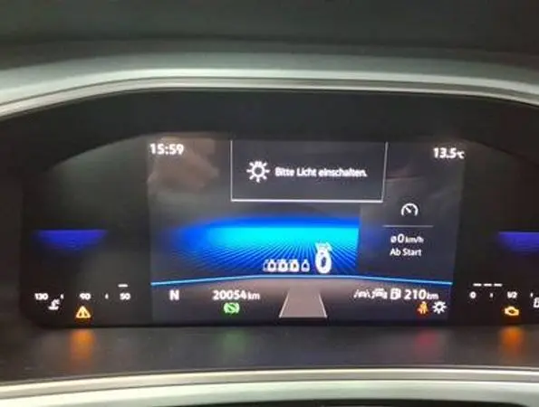 Tableau de bord numérique du Volkswagen T-Roc 2025 affichant la vitesse, la température et les alertes, avec fond bleu lumineux.