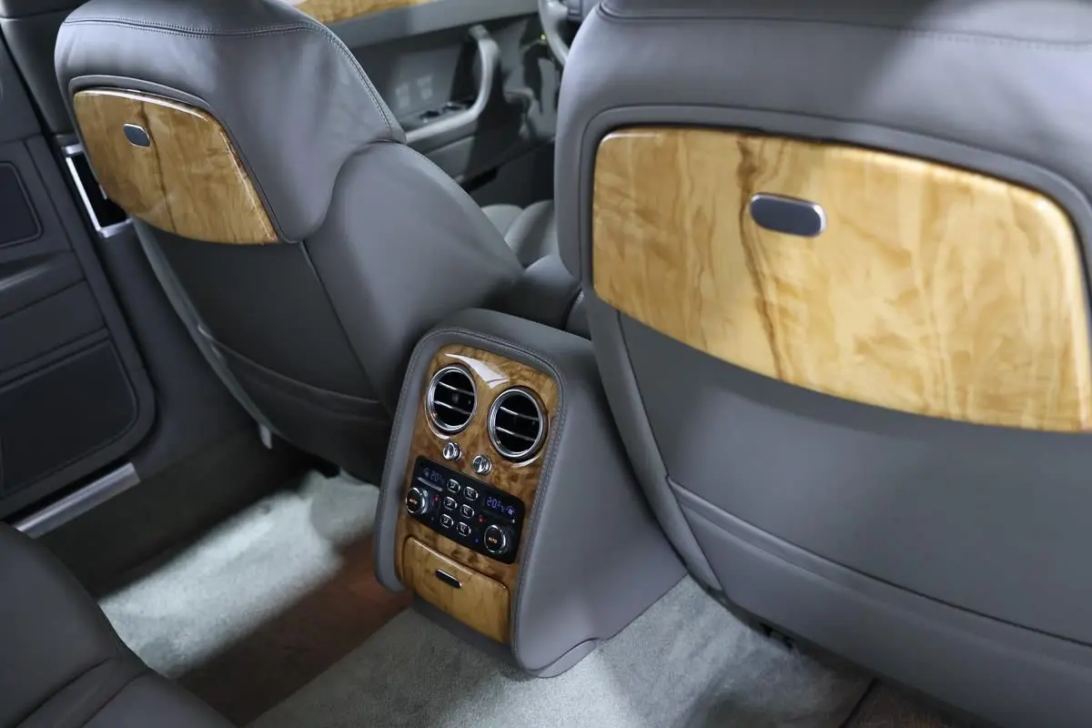 Vue intérieure arrière de la Bentley Continental Flying Spur 2006, cuir gris et boiseries claires élégantes.